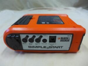 A professional car battery charger connected to a battery in a home garage.