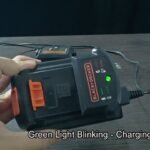 A cordless power tool battery being inserted into a Black and Decker charger.