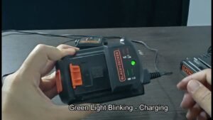 A cordless power tool battery being inserted into a Black and Decker charger.