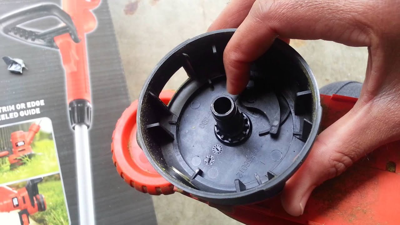 Debris and tangled line inside a cordless trimmer spool housing causing feed issues.