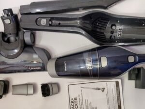 A modern cordless vacuum cleaner rests on a hardwood floor in a bright room.