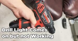 A cordless drill with a glowing LED light sits on a workshop bench.