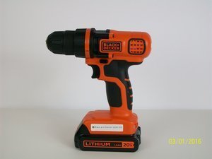 A professional cordless drill resting on a clean workbench in a workshop.