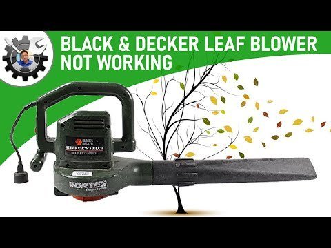 Hands cleaning debris from the air intake of an electric leaf blower.