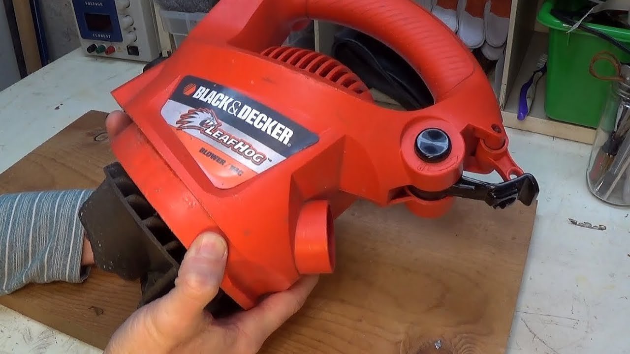 Repair tools arranged neatly beside an electric leaf blower on a workbench.