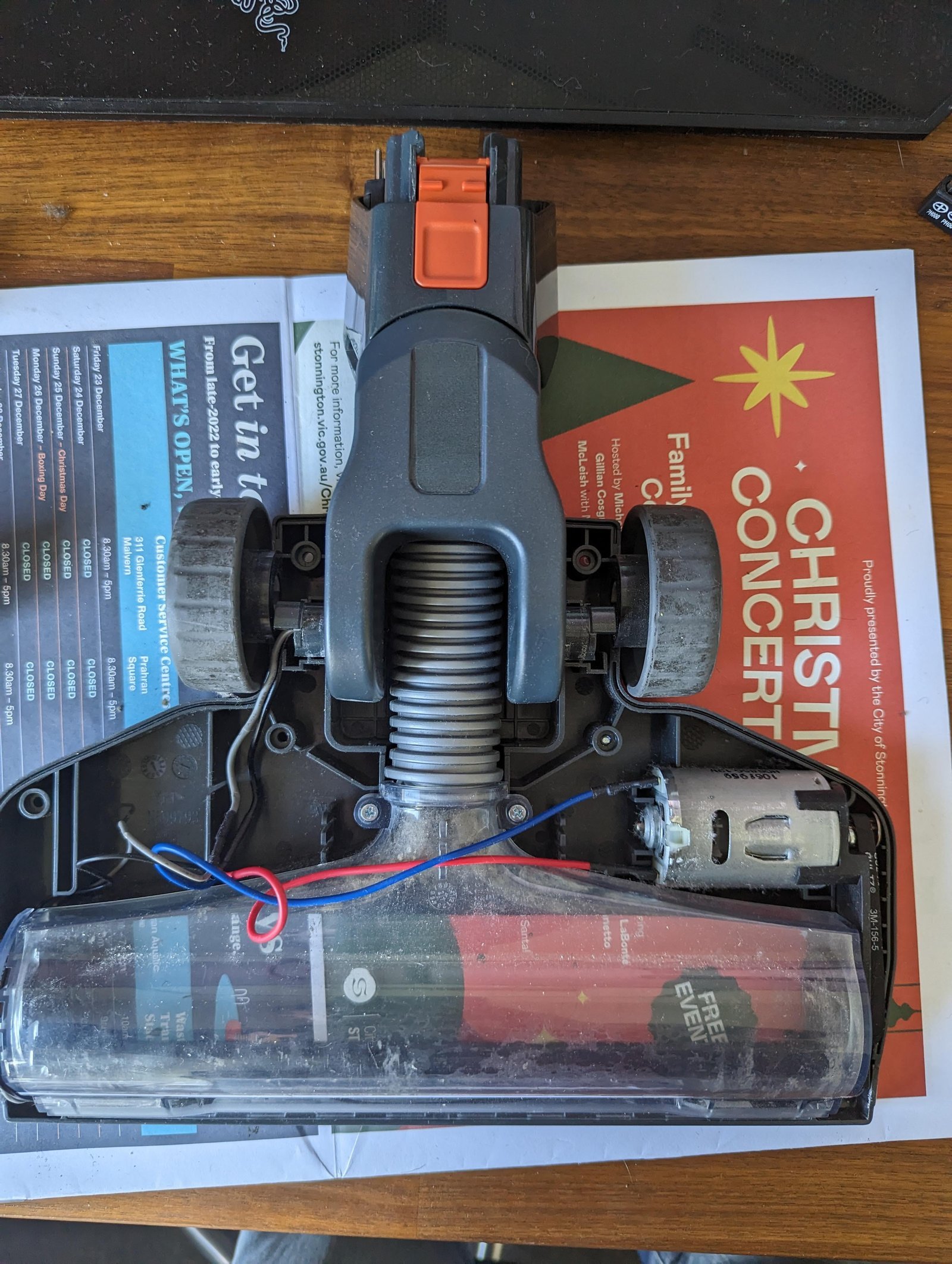 Cleaning debris from the intake nozzle of a handheld vacuum.