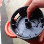 Maintenance being performed on a Black and Decker trimmer head to fix auto feed issues.