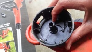 Maintenance being performed on a Black and Decker trimmer head to fix auto feed issues.