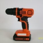 A Black and Decker drill on a workbench with tools for troubleshooting.