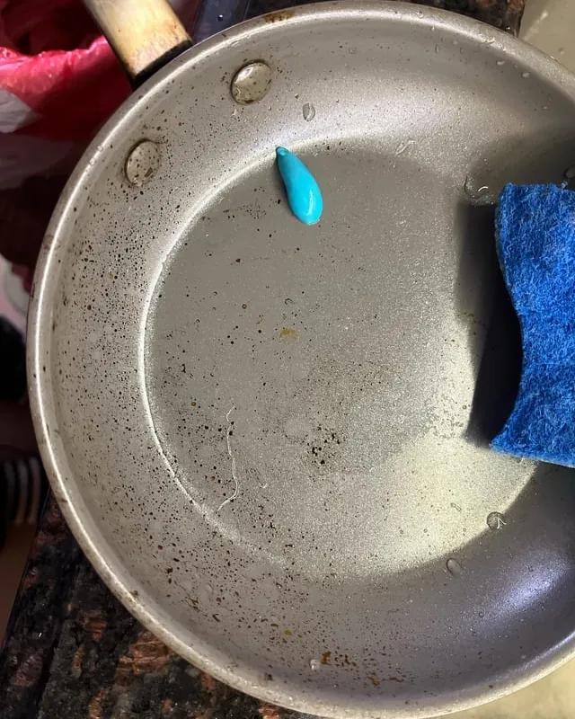 A ceramic frying pan surface showing dark heat damage and discoloration.