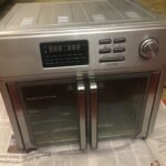 A clean modern air fryer sits on a kitchen counter ready for troubleshooting.