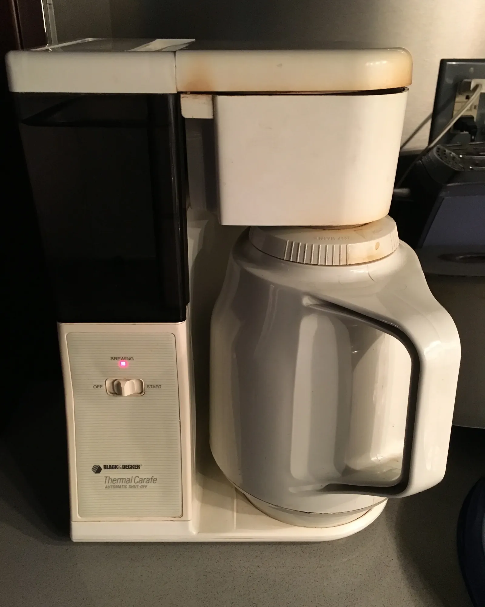 Cleaning the showerhead of a coffee maker to ensure machine longevity.