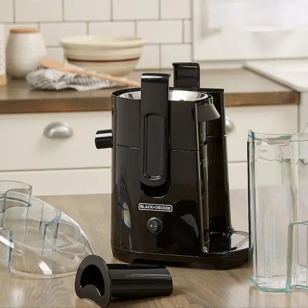 Clearing excess fruit pulp from a clogged juicer chute to prevent motor overheating.