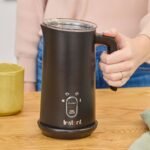 An electric milk frother sits on a kitchen counter during the morning.