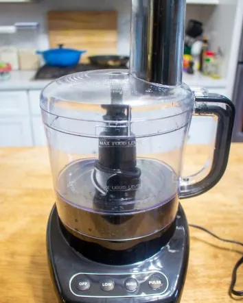 Hands aligning the lid of a food processor to fix a common issue.