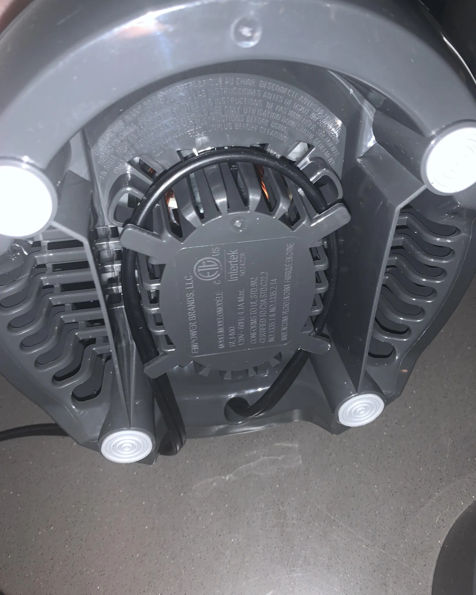 Hands checking the connection between a blender jar and its motor base.