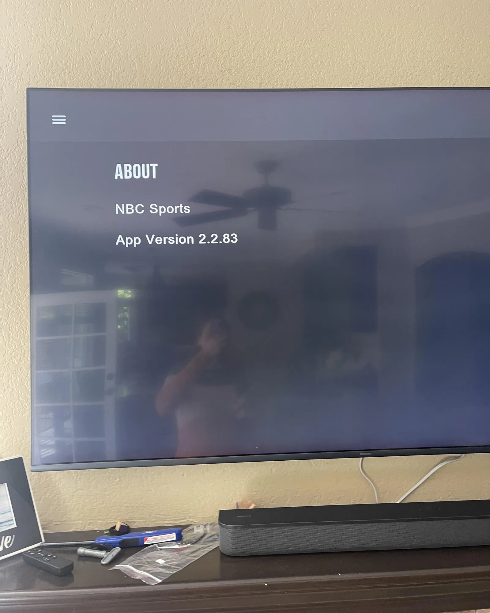 Hands navigating a settings menu on a tablet to fix sports app issues.