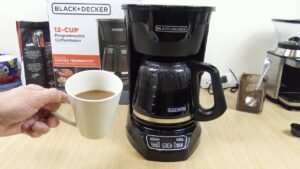 A modern drip coffee maker on a clean kitchen counter in natural light.