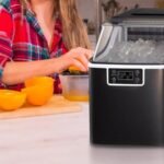 A modern Kismile ice maker sitting on a kitchen counter with fresh ice cubes.