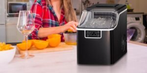 A modern Kismile ice maker sitting on a kitchen counter with fresh ice cubes.