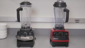 A modern kitchen blender disassembled on a marble countertop for troubleshooting.