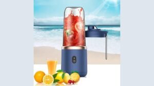 A modern portable blender on a kitchen counter with fresh fruit nearby.