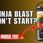 A modern portable blender sits on a counter with fresh fruit ingredients nearby.
