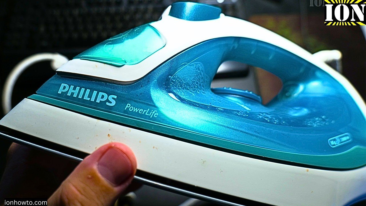 Checking the water level in a Philips iron tank to diagnose spray issues.