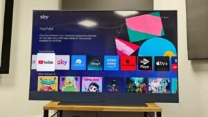 A black Philips television screen mounted on a wall in a modern living room.