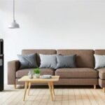 A portable space heater unplugged on a hardwood floor in a living room.