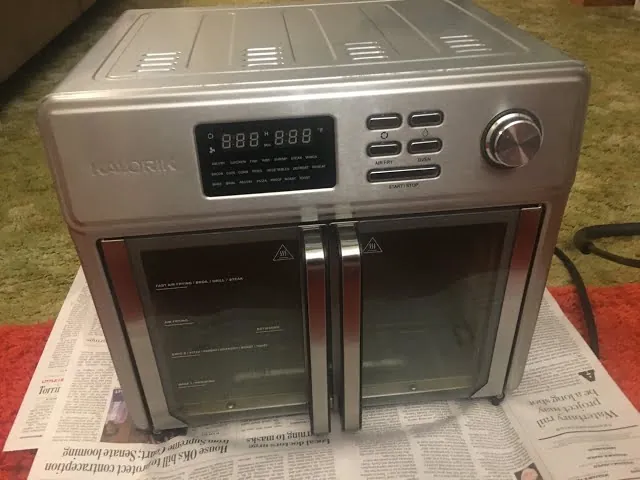 Securing the air fryer basket to ensure the safety microswitch is fully engaged.