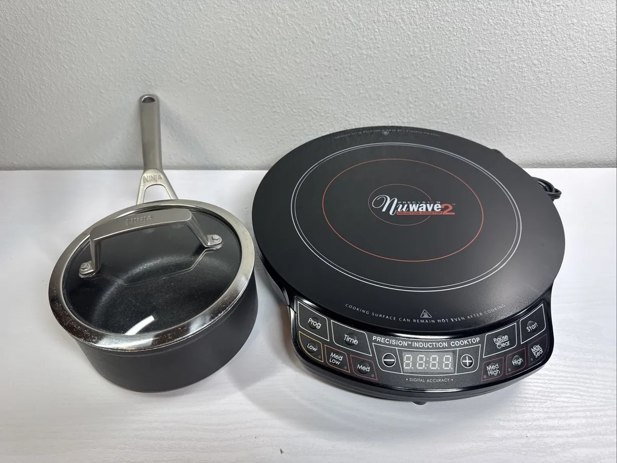 A small butter warmer pan sitting on a large induction cooktop burner zone.