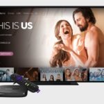 A Roku remote on a table with a television showing connection issues.